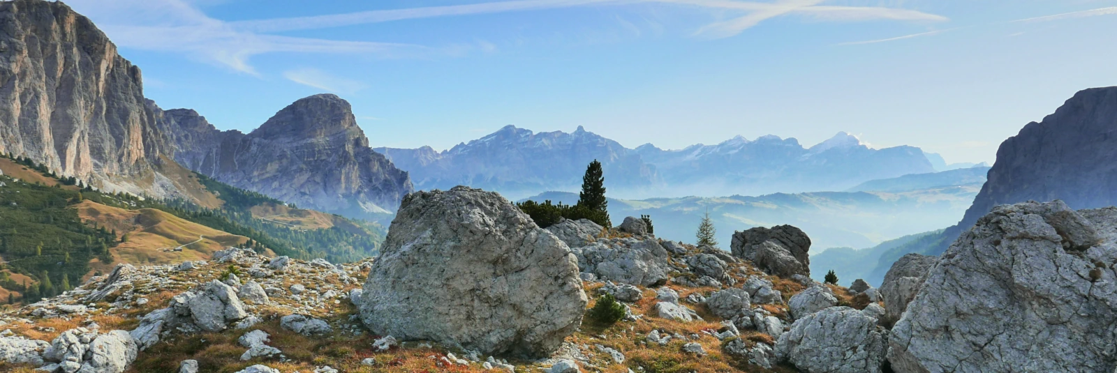 Scattered limestone rocks and autumn alpine terrain near Passo Gardena along a trail traversing the Sella Group