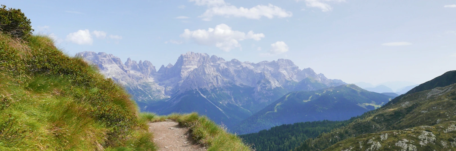 Panoramic view of the Brenta Dolomites peaks captured from a high-altitude trail on the Presanella range on a clear day