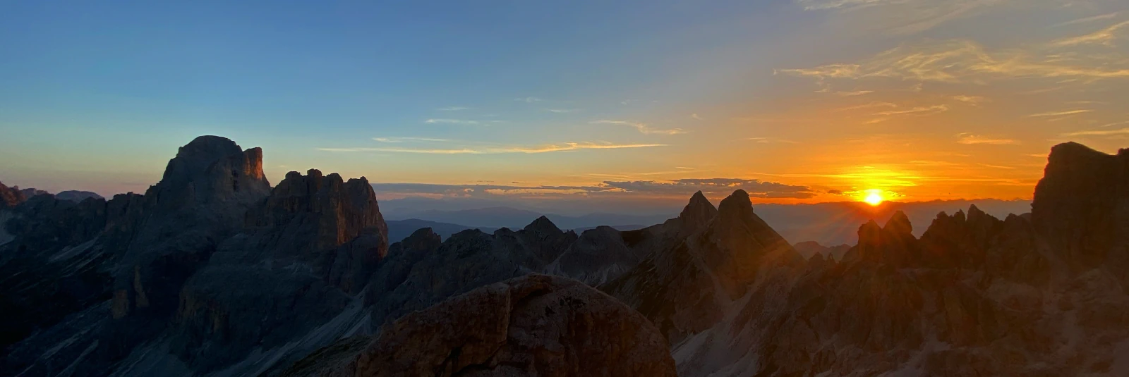 Dark rocky outlines of the Rosengarten massif standing out against a fading sunset sky near Passo d'Antermoia