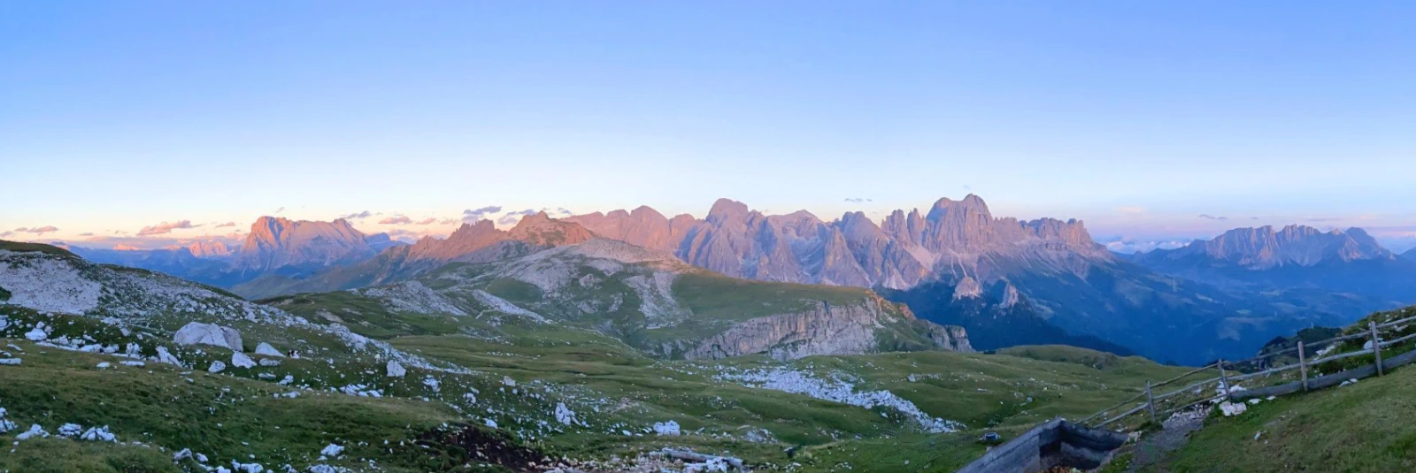 Alpenglow on Rosengarten, Sassolungo, and Latemar under soft pastel sky colors near Schlernhaus in the Sciliar massif